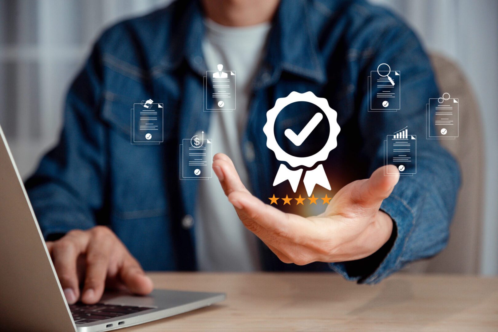 Hand holding digital certification icon near laptop.